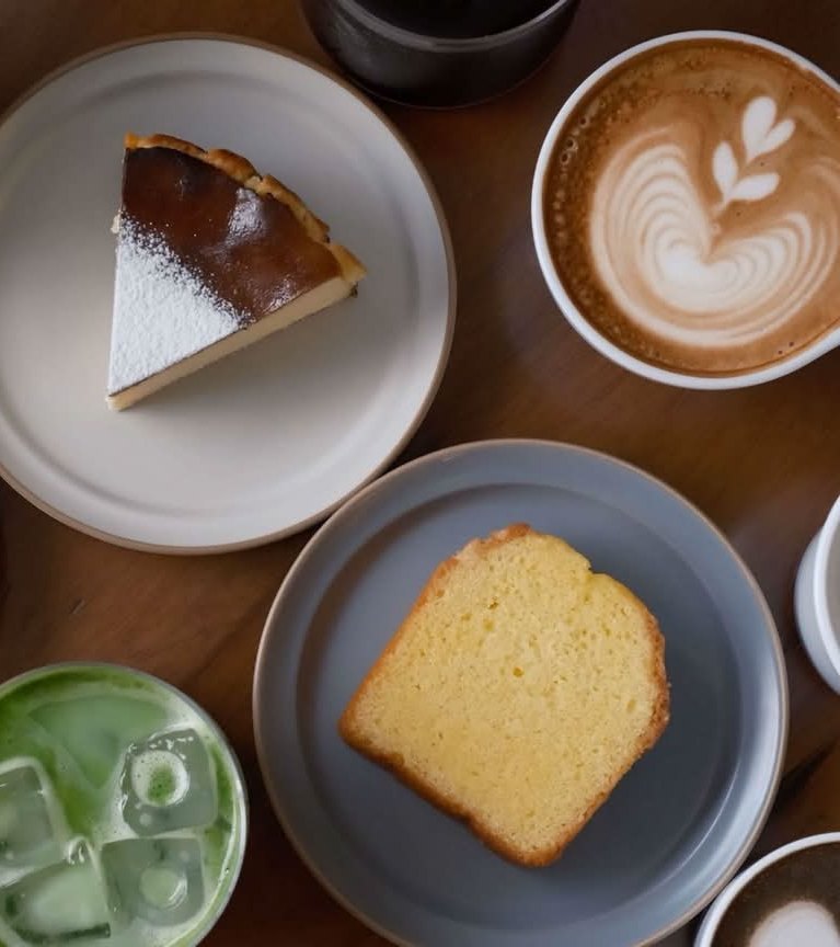 バスクチーズケーキ、パウンドケーキ、カフェラテ、抹茶ラテが並んだテーブル