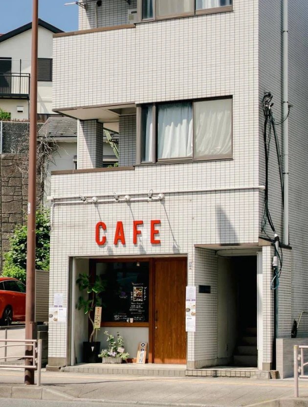 メリハリベイクの外観。白いタイルの建物に赤い「CAFE」の文字